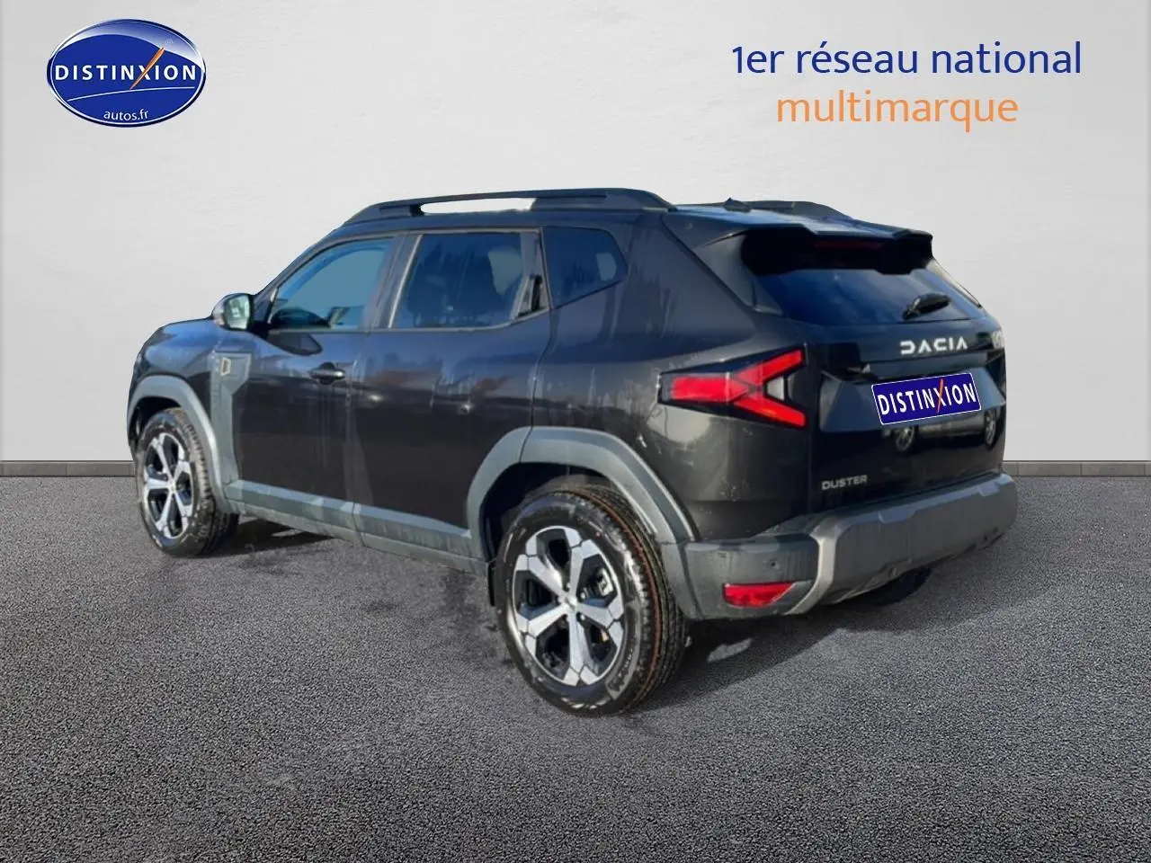 Vue 3/4 arrière droite du Dacia Duster noir 2026 avec barres de toit et jantes alliage distinctives.