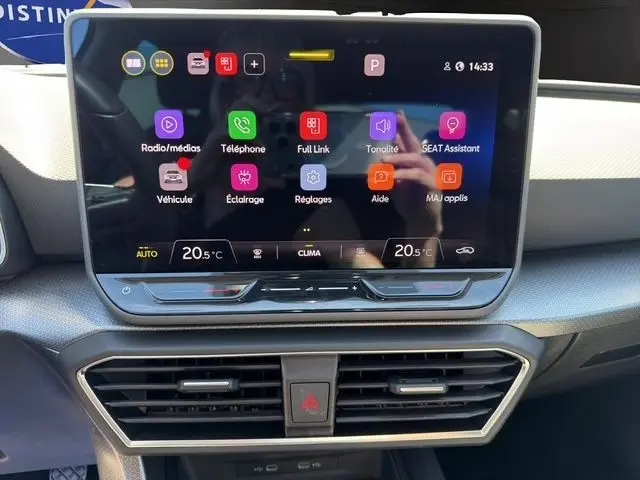 Écran tactile central de 10,3 pouces du tableau de bord du SEAT Leon blanc, affichant le menu multimédia et climatisation.