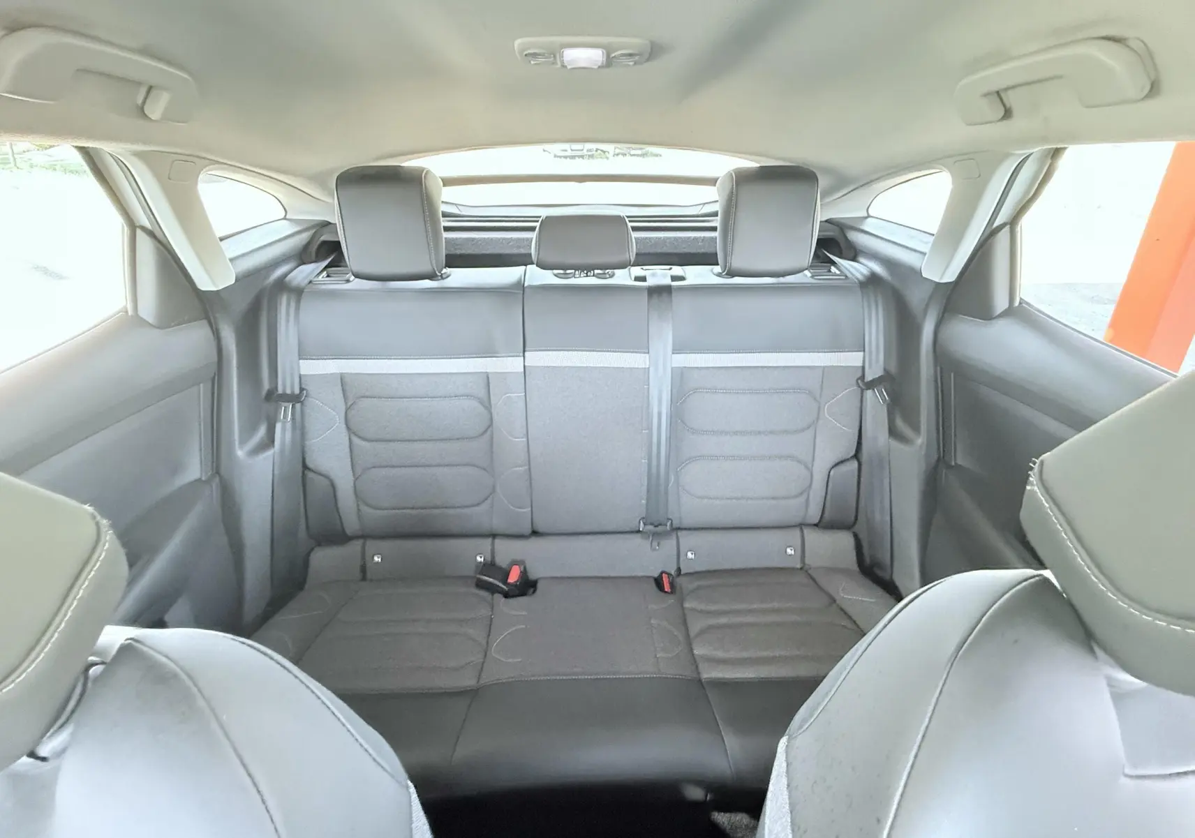 Vue intérieure arrière de la banquette arrière en tissu gris noir du Citroën C4 2023, version diesel blanche.