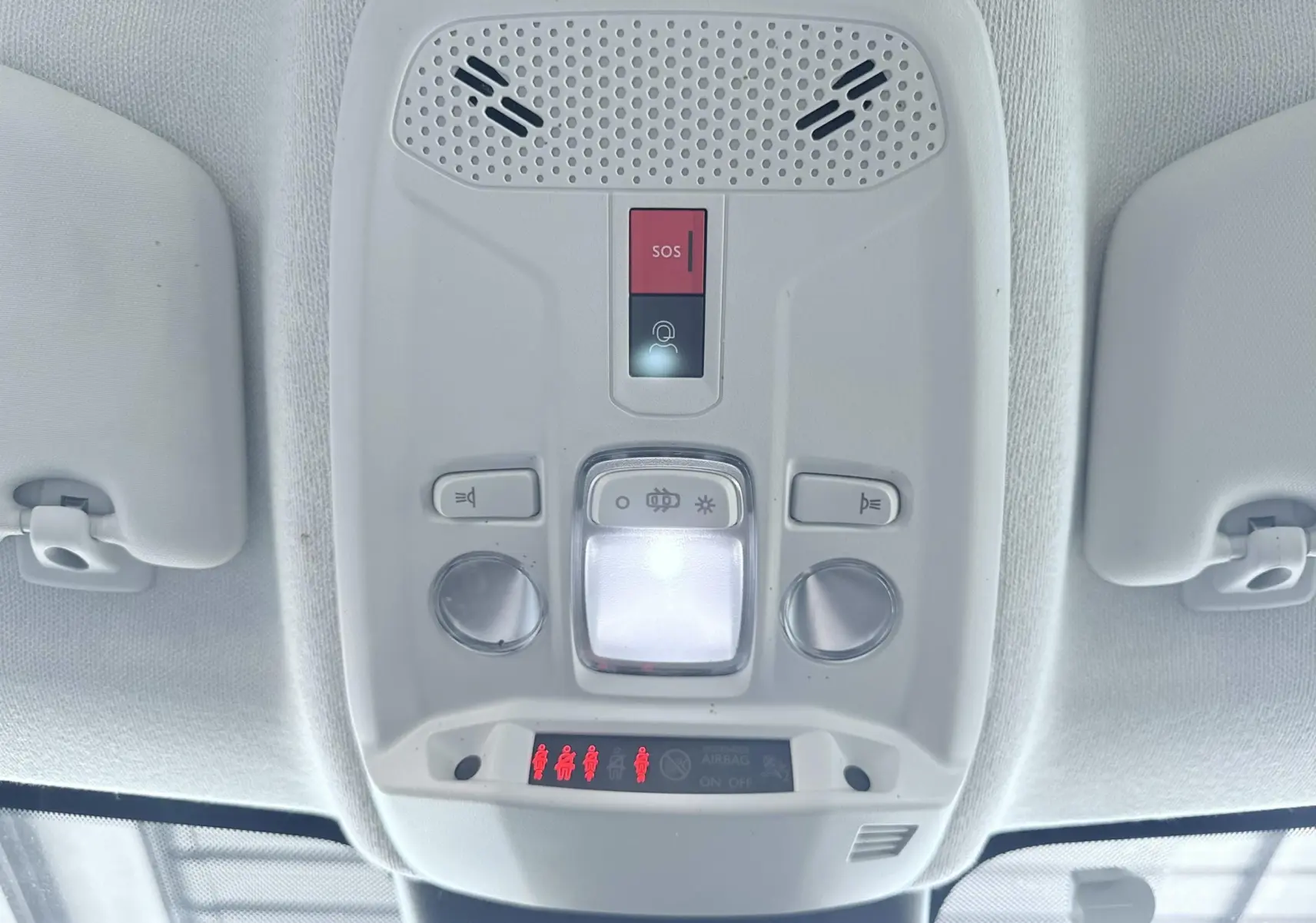 Vue en gros plan du plafonnier intérieur blanc avec boutons SOS et éclairage d'une Citroën C4 2023.