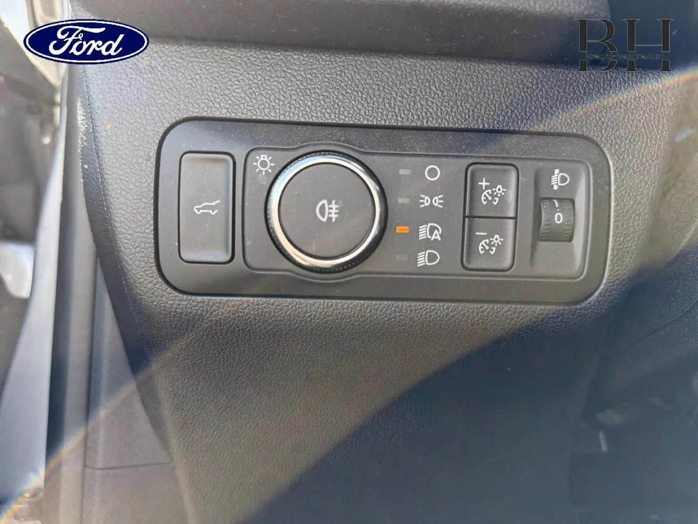 Gros plan sur les commandes d’éclairage intérieures du Ford Kuga 2024, avec finition noire texturée.