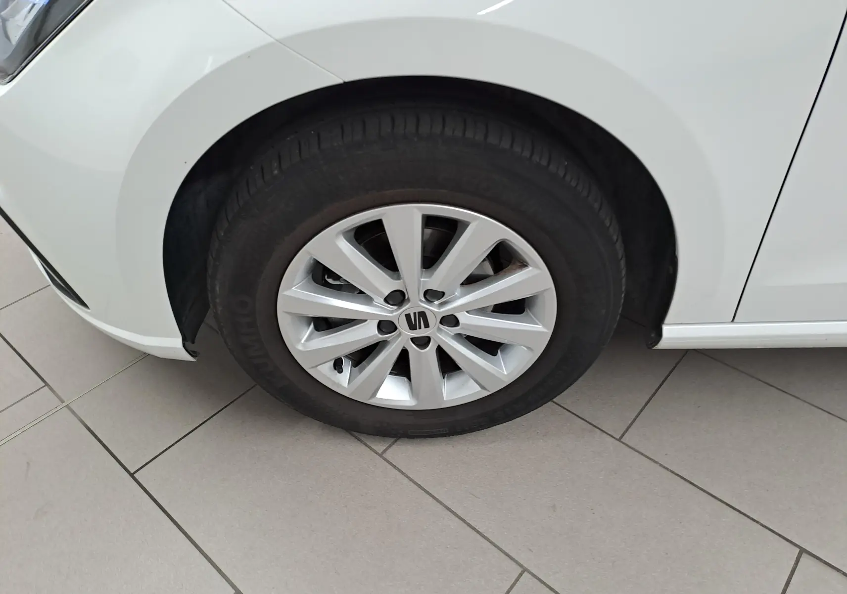 Gros plan sur la roue avant gauche d'une SEAT Ibiza blanc candy 2023 avec jante alliage et pneu Dunlop.