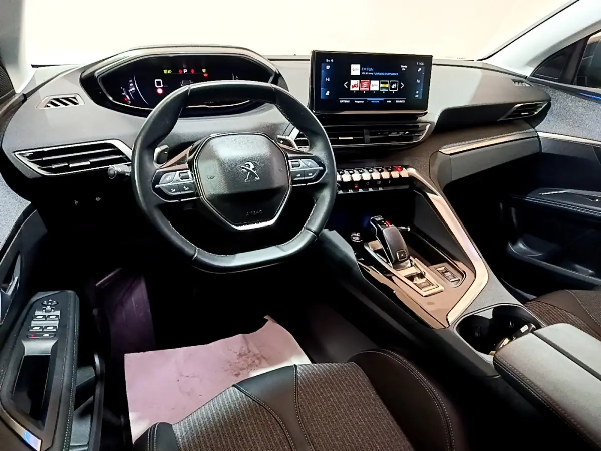 Intérieur du Peugeot 3008 gris foncé, vue côté conducteur sur volant cuir et écran tactile central lumineux.