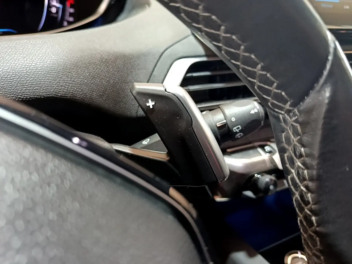 Gros plan sur la palette de changement de vitesse côté gauche du volant cuir du Peugeot 3008 gris foncé 2022.