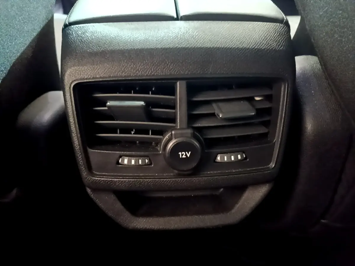 Gros plan sur la prise 12V et les bouches d'aération arrière noires du Peugeot 3008 gris foncé, version 2022.