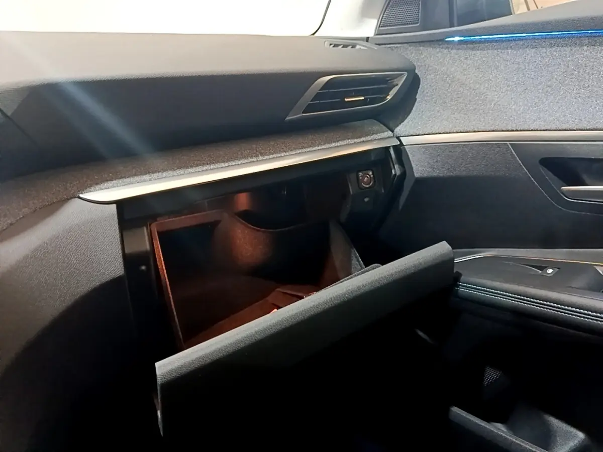 Intérieur PEUGEOT 3008 2022, vue côté passager sur boîte à gants ouverte et tableau de bord gris foncé.