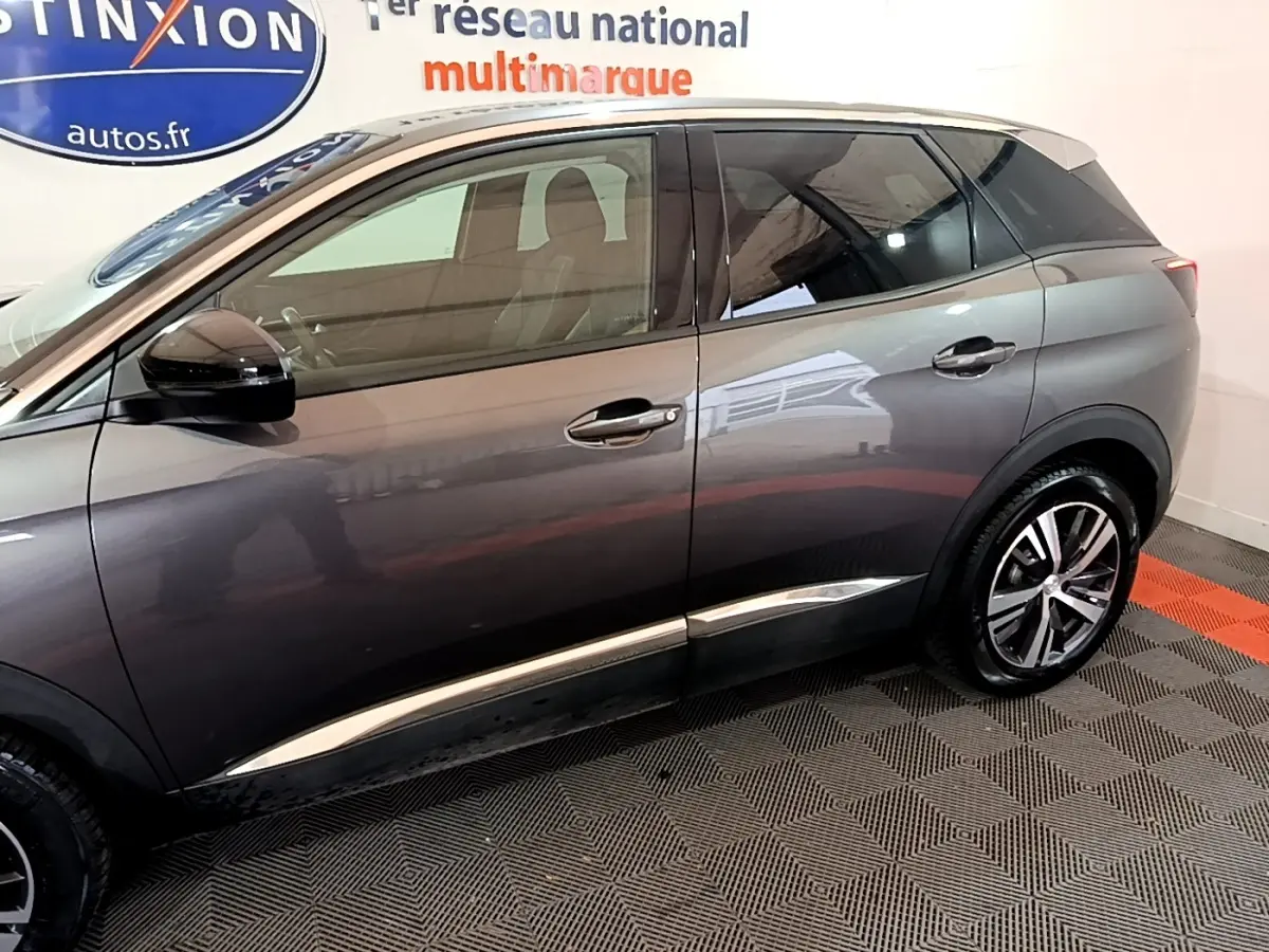 Profil côté gauche du Peugeot 3008 gris foncé 2022 avec jantes alliage et détails chromés sur les portières.