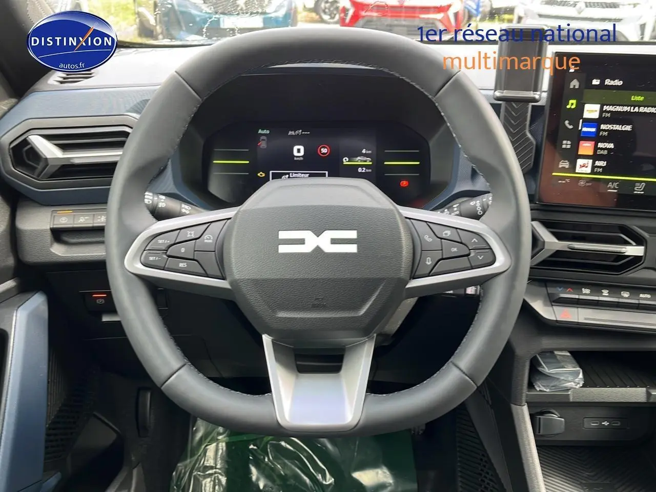 Vue frontale du volant multifonction et tableau de bord numérique du Dacia Duster gris schiste 2025, intérieur moderne.