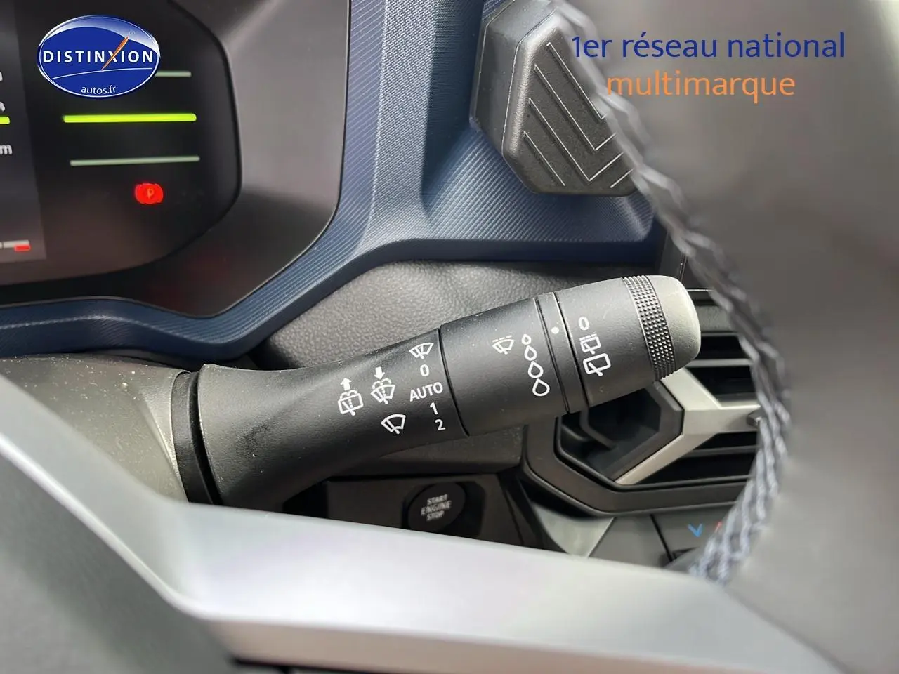 Gros plan sur la commande d’essuie-glace du tableau de bord bleu et noir du Dacia Duster gris schiste 2025.