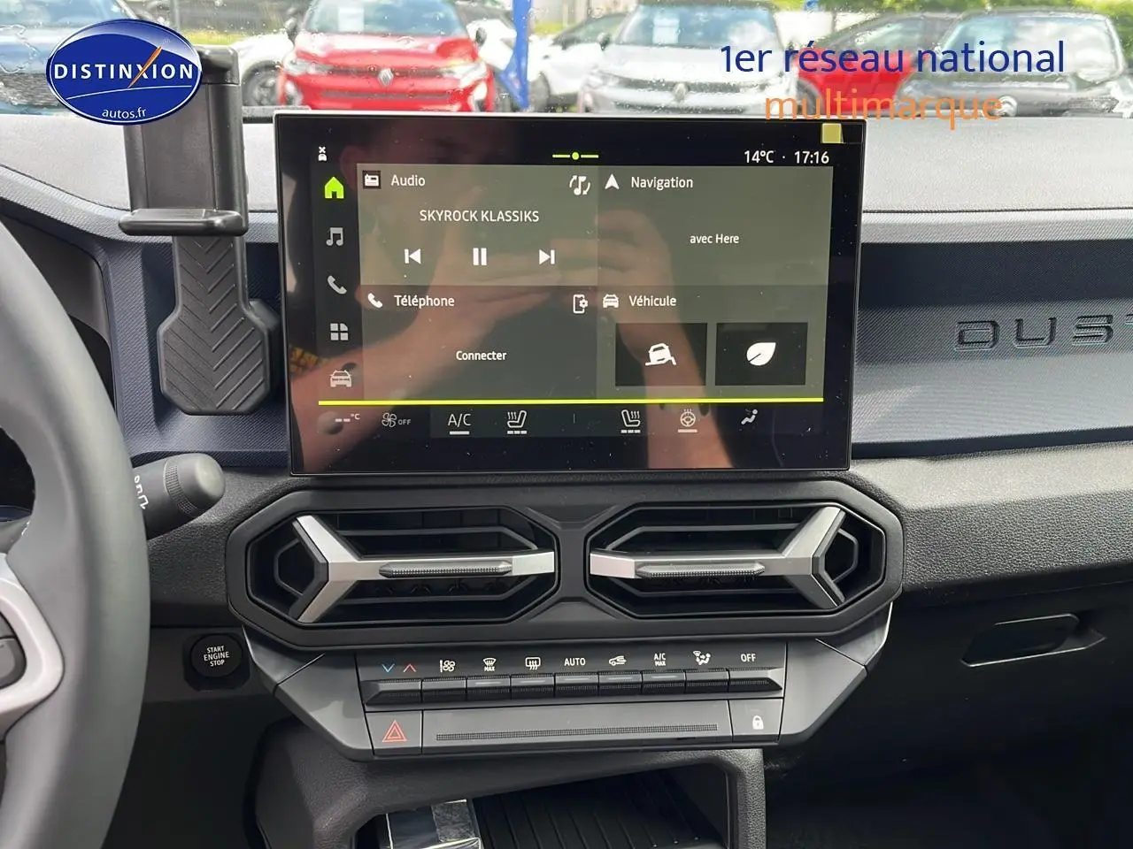 Vue intérieure du tableau de bord du Dacia Duster gris schiste 2025, avec écran tactile central et aérateurs hexagonaux.