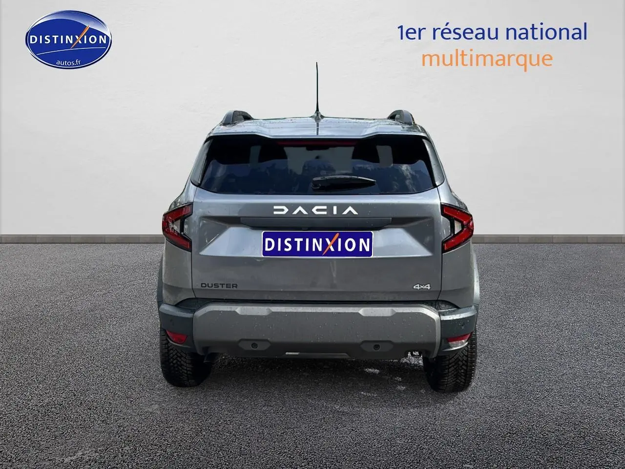 Vue arrière du Dacia Duster gris schiste 2025 avec logo DACIA et badge 4x4 visible sur un fond neutre.