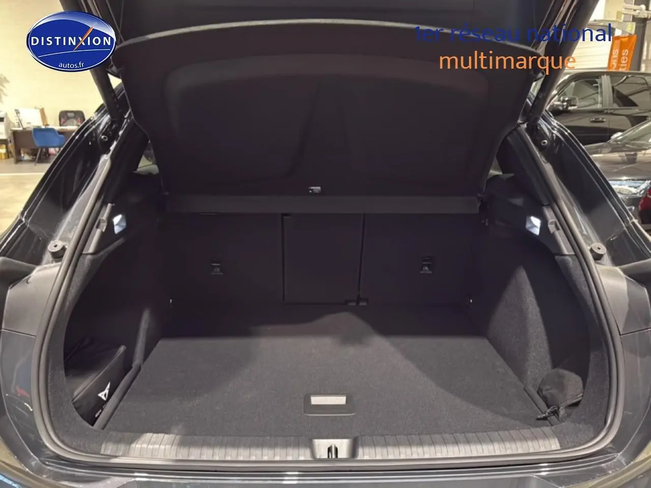 Coffre ouvert d'une CUPRA Terramar gris, vue arrière montrant l'espace de chargement vide et bien fini.
