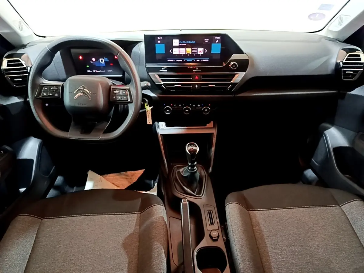 Vue intérieure avant de la Citroën C4 2021, tableau de bord noir avec écran tactile 10 pouces et boîte manuelle.