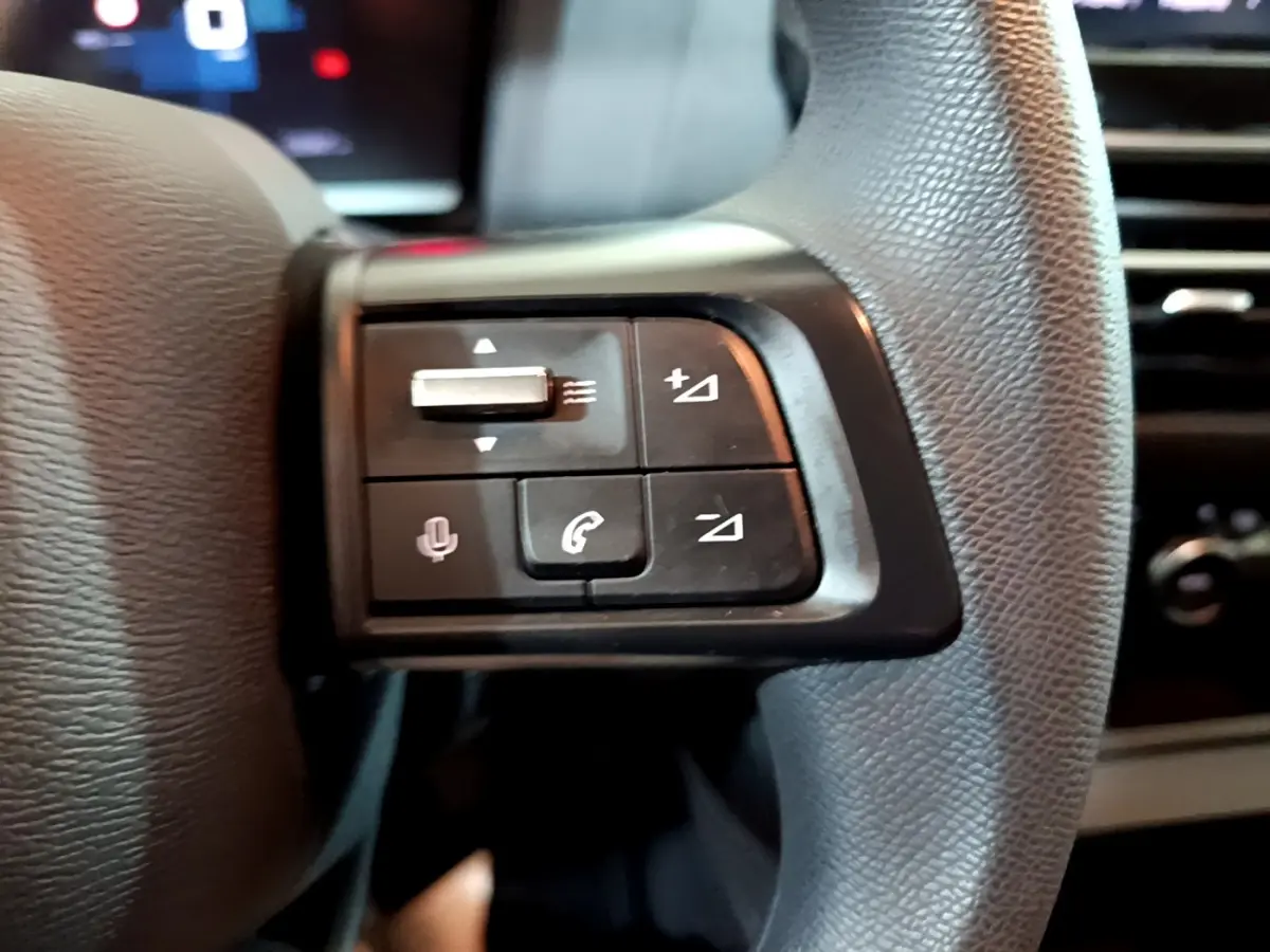 Gros plan sur les commandes multifonctions du volant en cuir noir de la Citroën C4 2021, côté gauche.