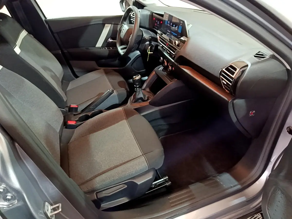 Vue intérieure côté conducteur de la Citroën C4 gris foncé 2021, avec tableau de bord moderne et sièges tissu gris.