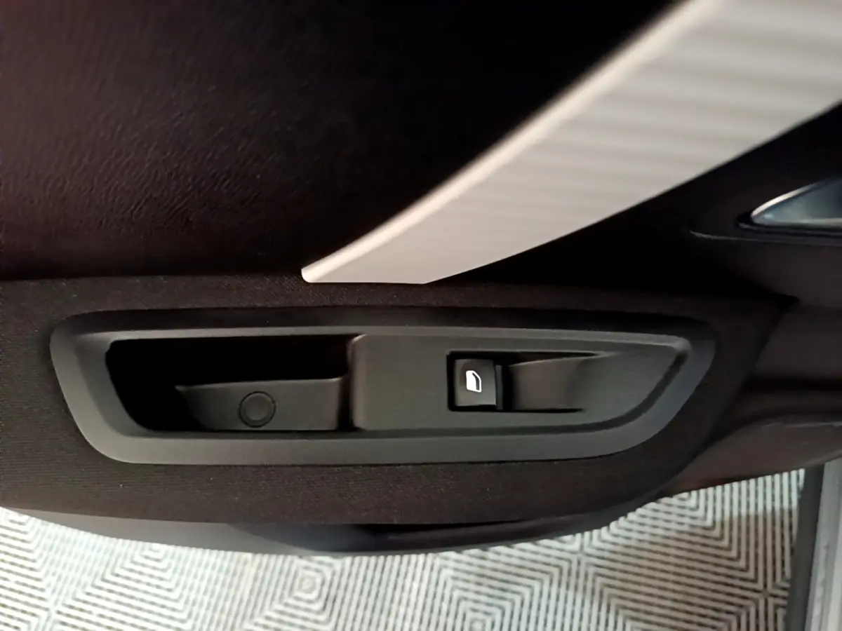 Poignée intérieure de porte arrière côté droit de Citroën C4 gris foncé, avec bouton de verrouillage.