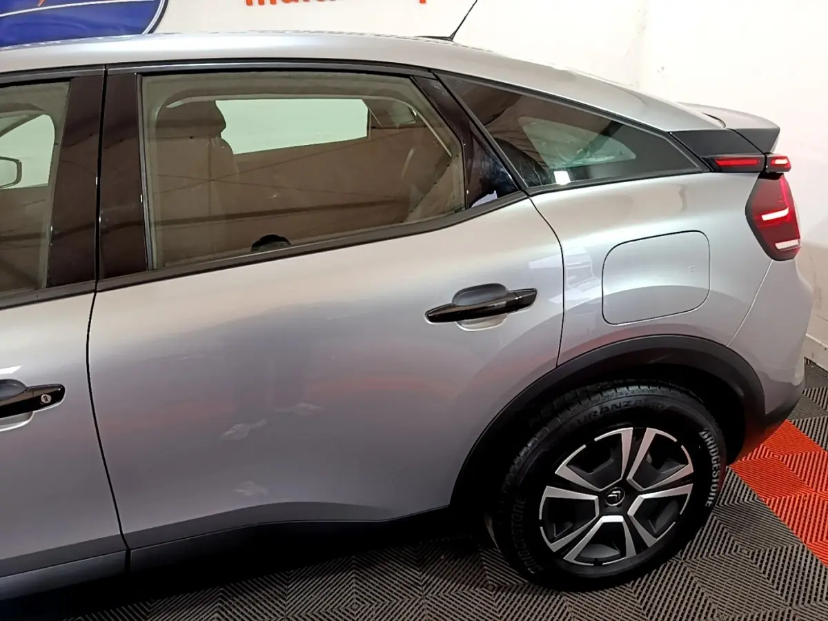 Vue côté droit arrière d'une Citroën C4 gris foncé avec jante alliage et feux arrière LED distinctifs.