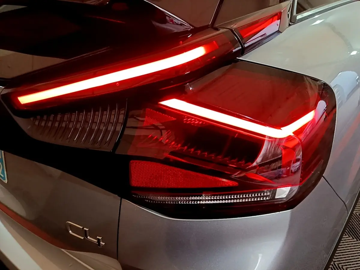 Gros plan sur le feu arrière droit allumé d'une Citroën C4 gris foncé, soulignant ses lignes LED distinctives.