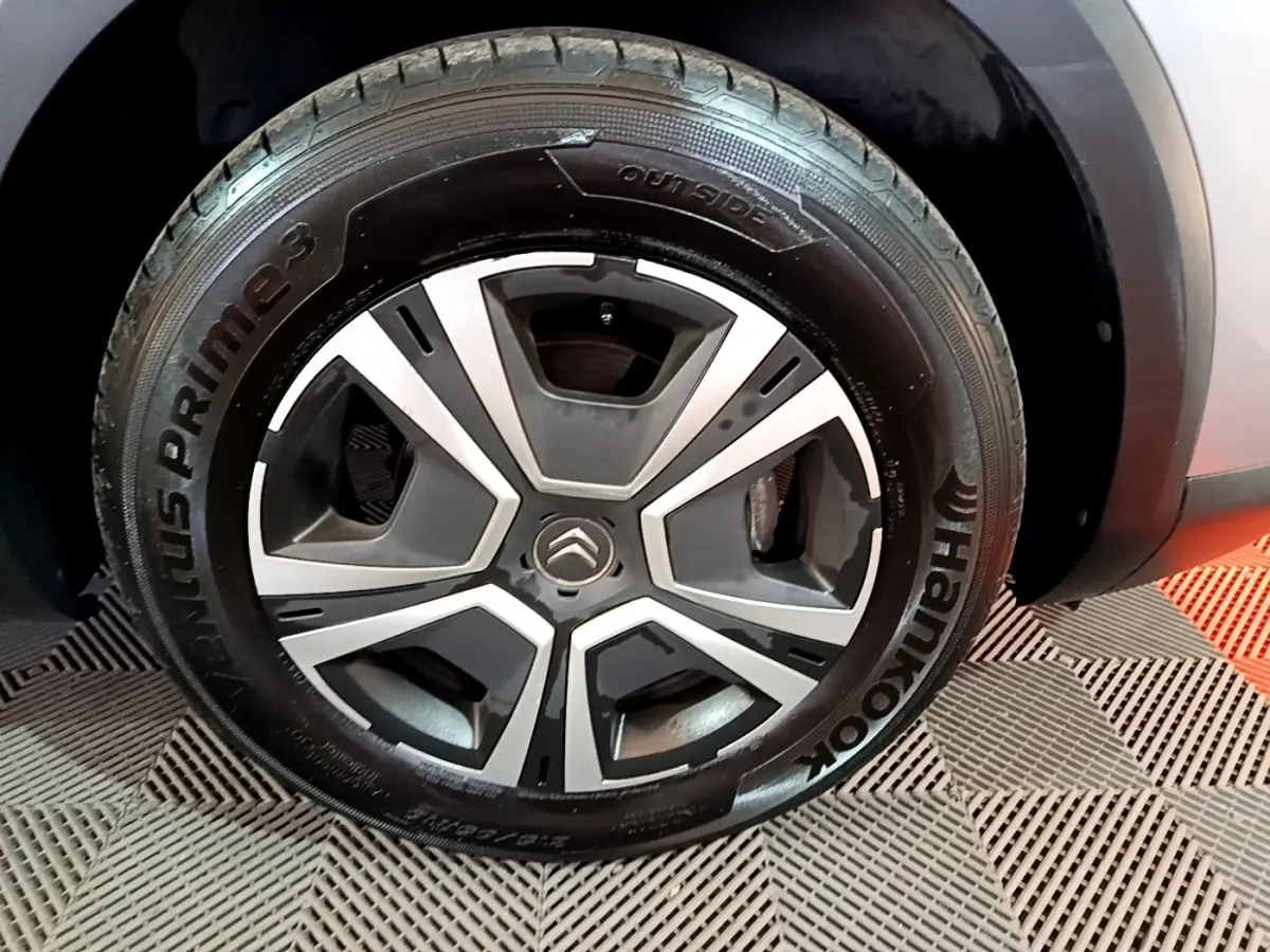 Gros plan sur la roue avant droite gris foncé de la Citroën C4 avec jante au design moderne bicolore.