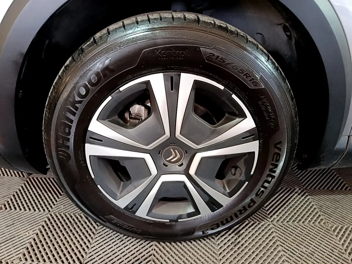 Gros plan sur la roue avant gauche d'une Citroën C4 gris foncé avec jante alliage et pneu Hankook.