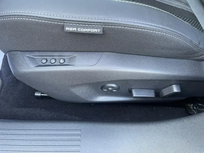 Détail du réglage électrique du siège avant droit noir avec étiquette AGR Comfort sur Peugeot 408 Hybrid 2024.