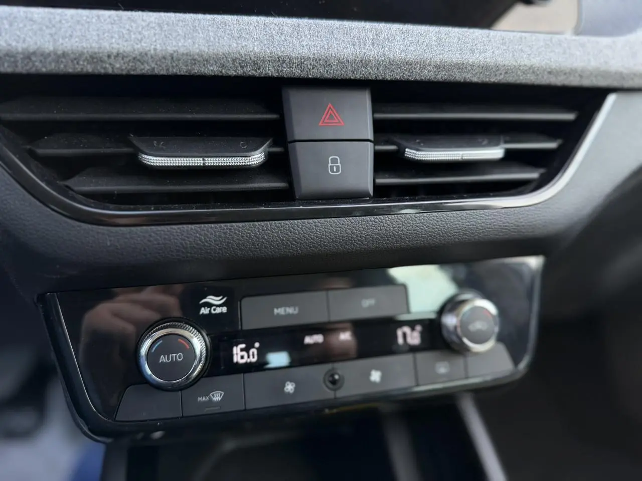 Détail du tableau de bord de la Skoda Scala TSI 116 blanc, montrant la climatisation automatique bi-zone avec commandes digitales.