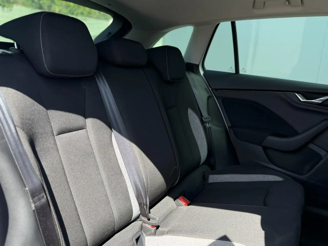 Vue latérale droite de la banquette arrière noire et grise de la Skoda Scala TSI 116 Sélection 2025.