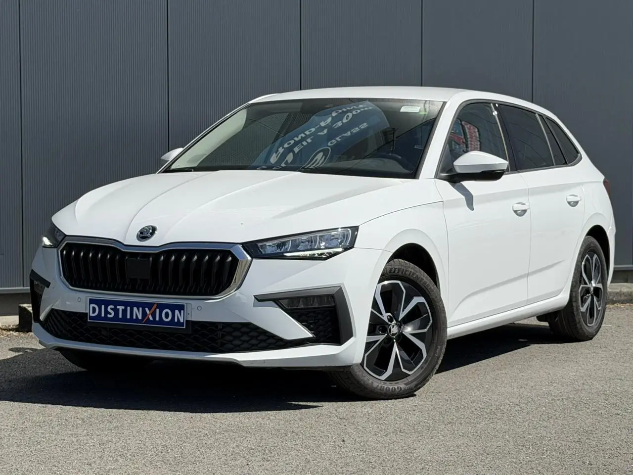 Skoda Scala blanc glacier vue 3/4 avant droit avec jantes alliage et vitres surteintées.