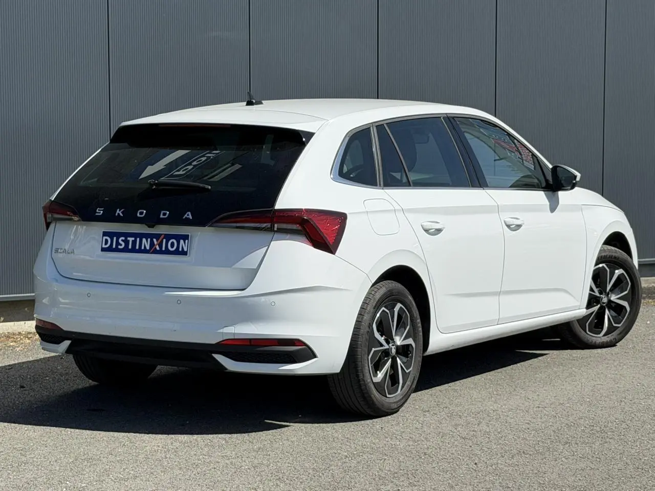 Vue 3/4 arrière droite d'une Skoda Scala blanc glacier avec vitres surteintées et jantes alliage 16 pouces.