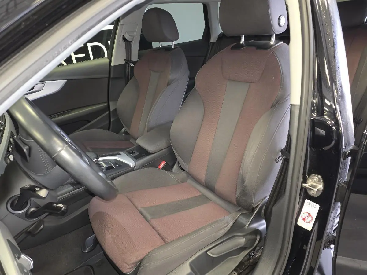 Vue intérieure côté gauche de l'Audi A4 Avant 2019 noire, sièges avant sport en tissu bicolore gris et marron.