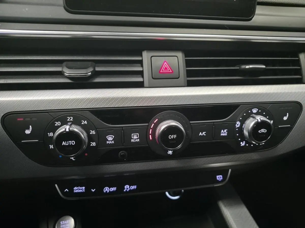 Détail du tableau de bord de l’Audi A4 2019 noir, montrant les commandes de climatisation et chauffage des sièges.