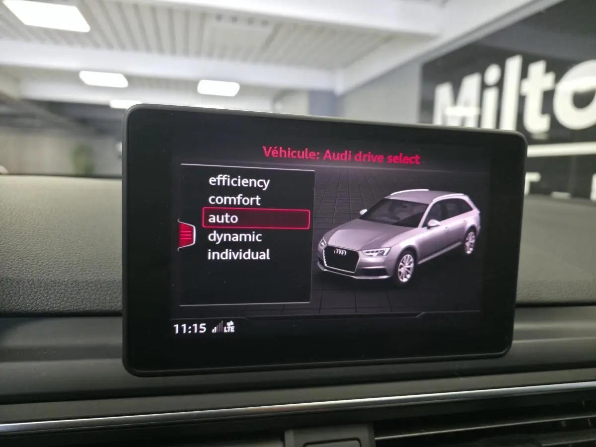 Écran du système Audi Drive Select montrant une Audi A4 Avant grise en vue 3/4 avant droite.
