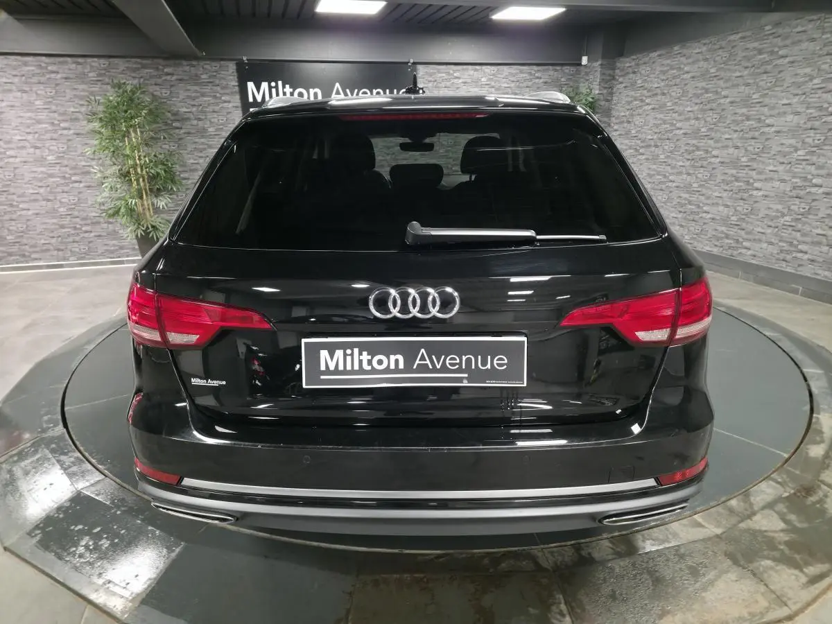 Vue arrière d'une Audi A4 Avant noire de 2019 avec feux rouges et double sortie d'échappement chromée.