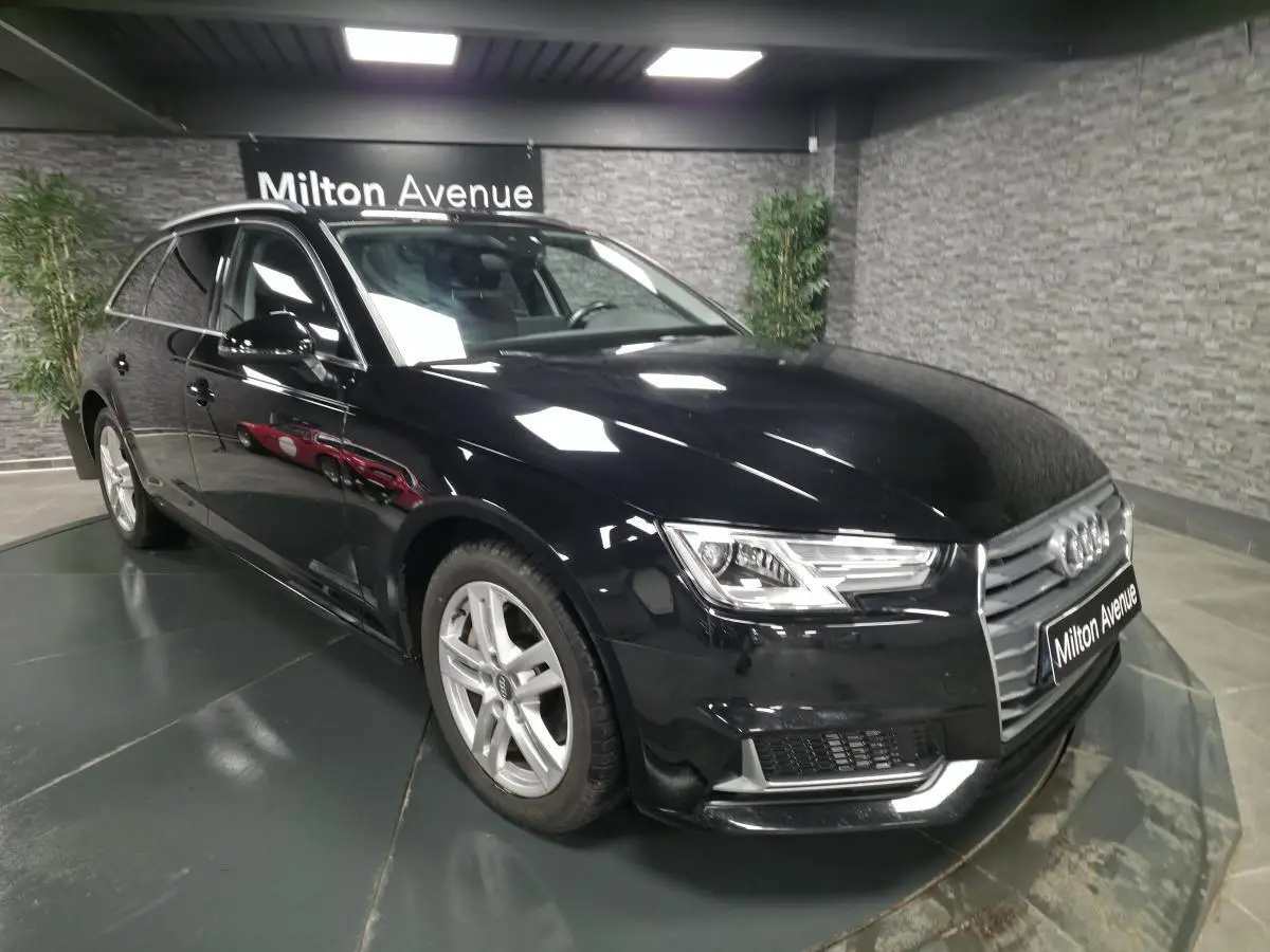 Audi A4 Avant noire vue en 3/4 avant droit, avec jantes aluminium 17 pouces et rétroviseurs noir brillant.