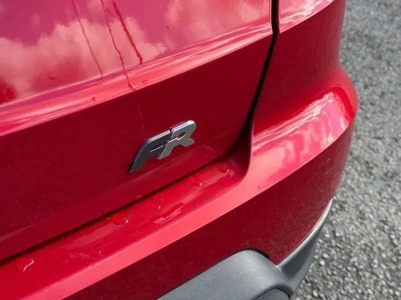 Gros plan sur l'arrière droit rouge Désir du SEAT Arona 2025 avec logo FR et pare-chocs noir mat visible.