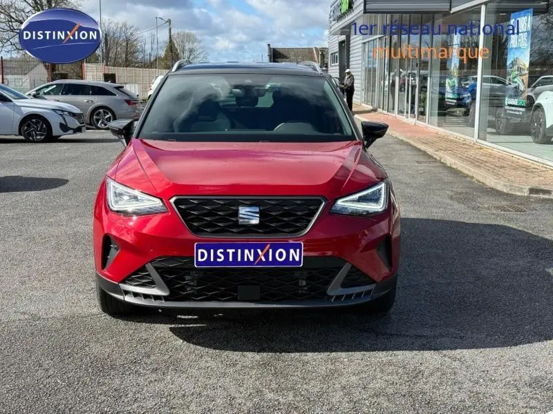 Vue avant d'un SEAT Arona 2025 rouge Désir avec toit noir, mettant en valeur sa calandre et ses phares LED anguleux.