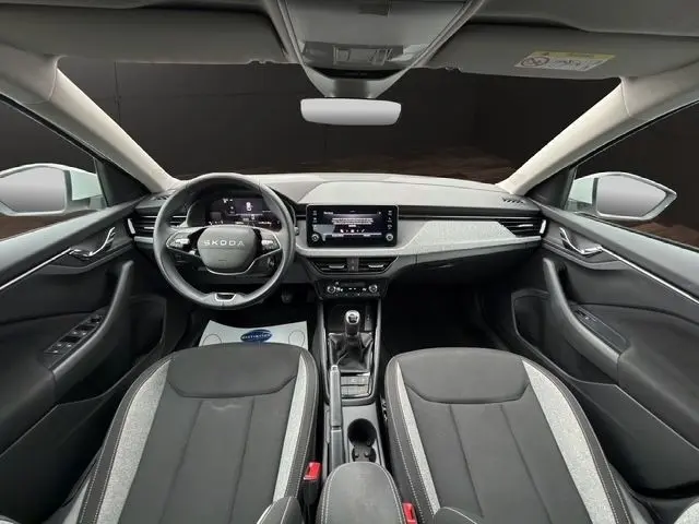 Vue intérieure frontale du Skoda Scala blanc 2025, tableau de bord moderne avec écran tactile et volant multifonctions cuir alu.