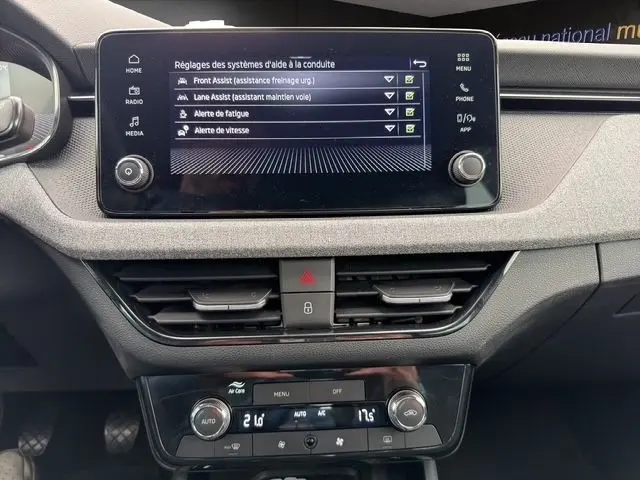Vue rapprochée du tableau de bord de la Skoda Scala blanche 2025, avec écran tactile affichant les aides à la conduite.
