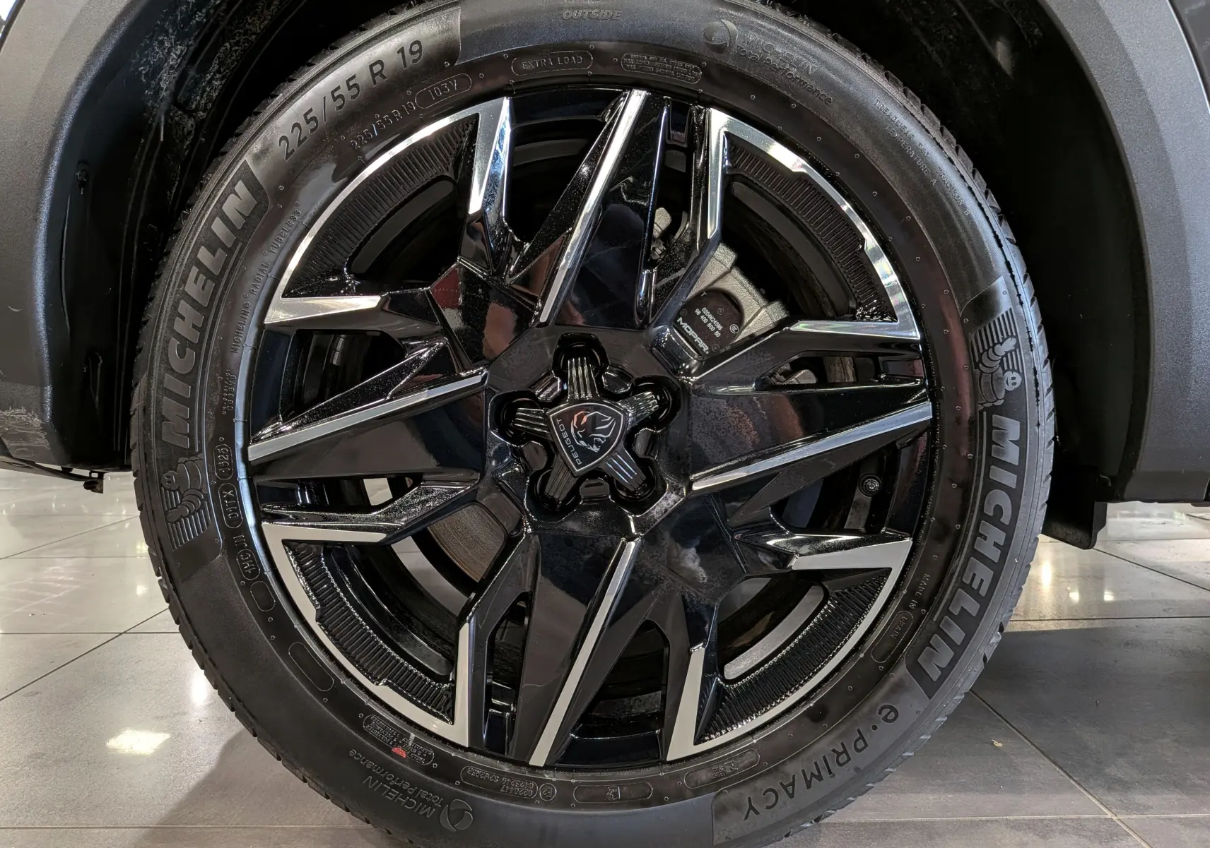 Gros plan sur la jante noire et chromée de 19 pouces d’un Peugeot 5008 Hybrid 2025, pneu Michelin visible.