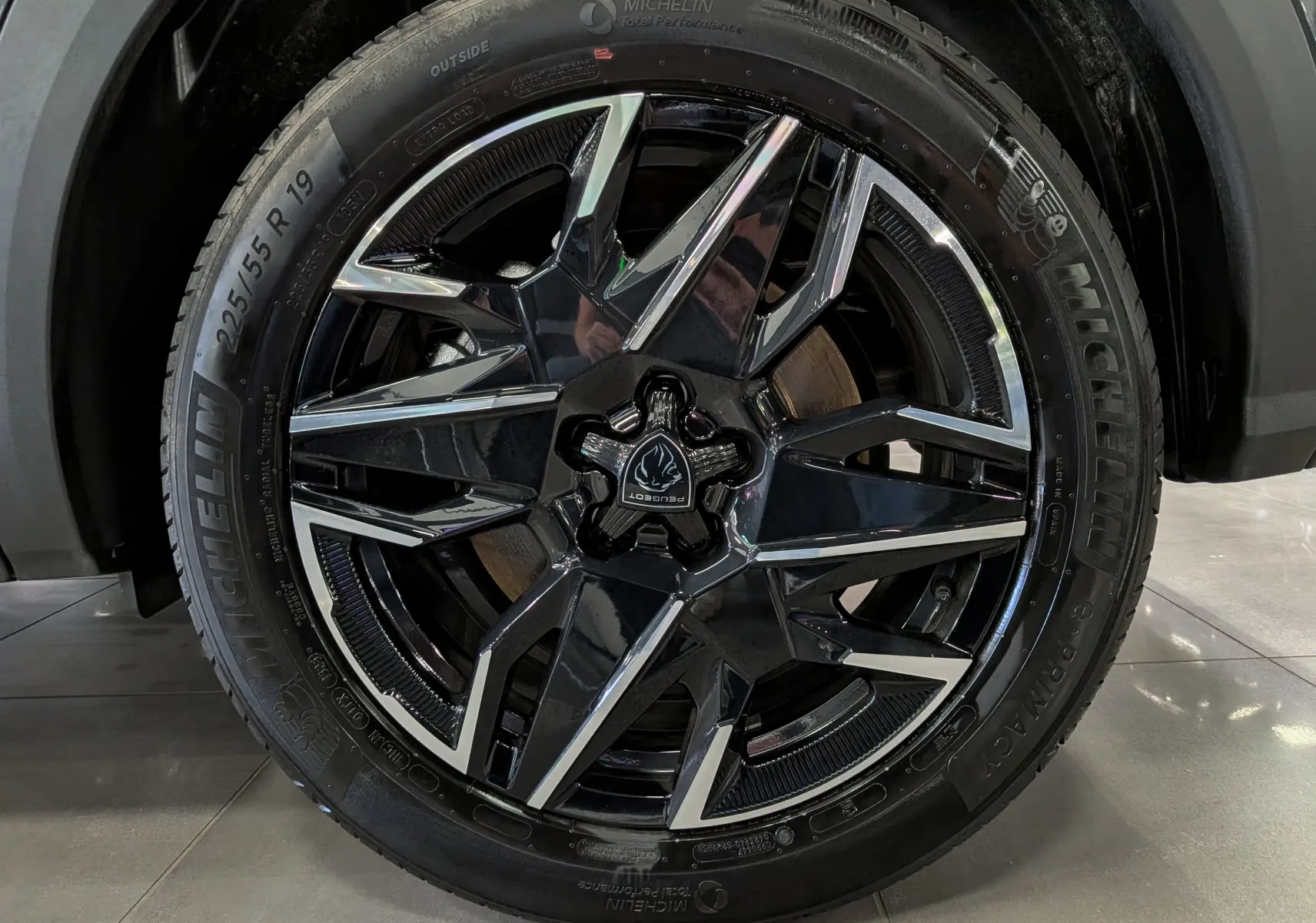 Gros plan sur la jante noire et argentée de 19 pouces d’un Peugeot 5008 Hybrid 2025 gris titane.