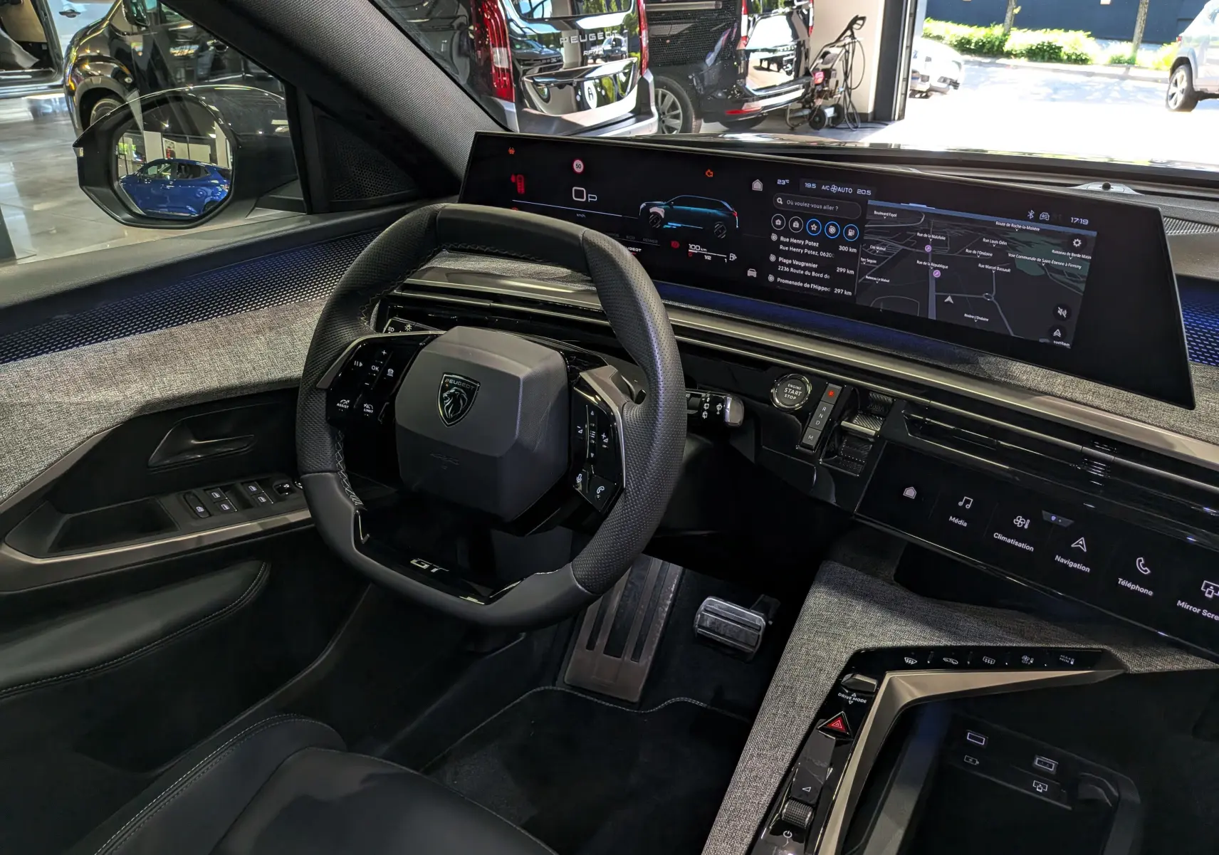Vue intérieure du poste de conduite du Peugeot 5008 Hybrid 145 GT 2025, avec volant compact et écran numérique panoramique.