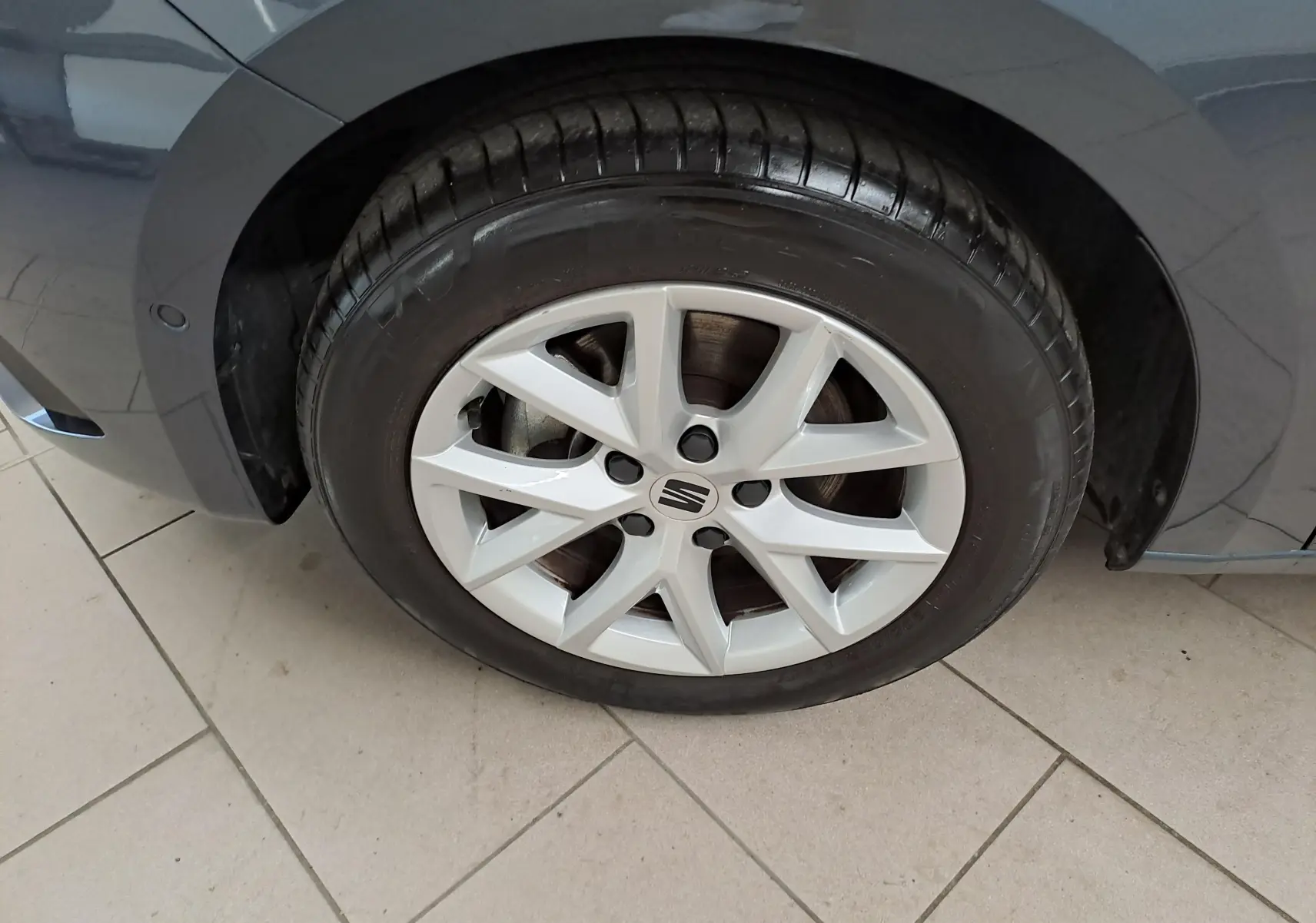 Gros plan sur la roue avant gauche du SEAT LEON gris magnétique 2025 avec jante alliage et carrosserie brillante.