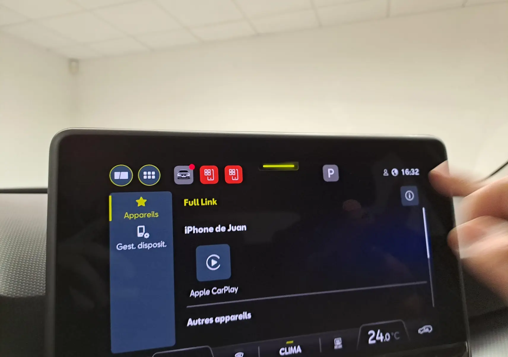 Écran tactile central du SEAT Leon 2025 montrant la connexion Apple CarPlay, avec main en mouvement à droite.