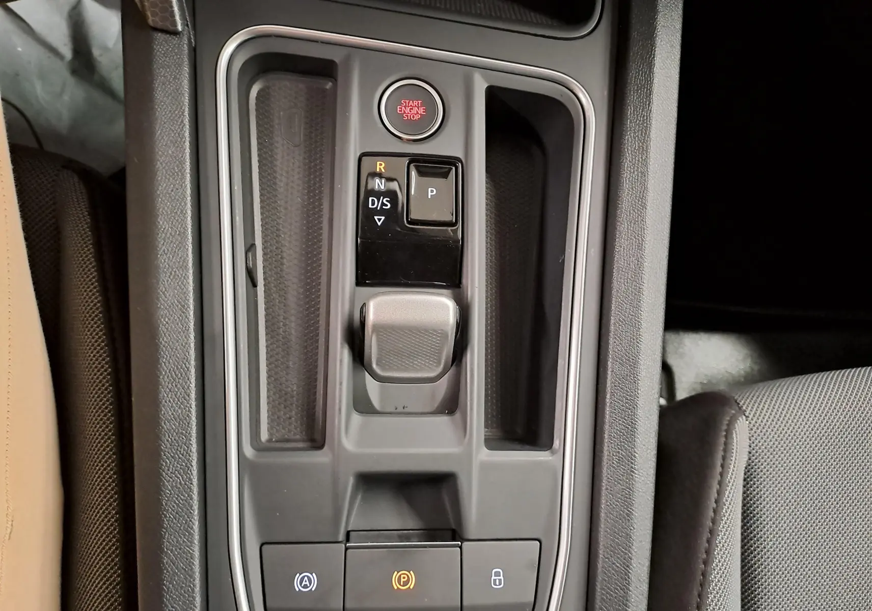 Vue rapprochée de la console centrale du SEAT LEON 1.5 eTSI Hybrid 2025, montrant la commande de boîte automatique et le bouton Start/Stop.