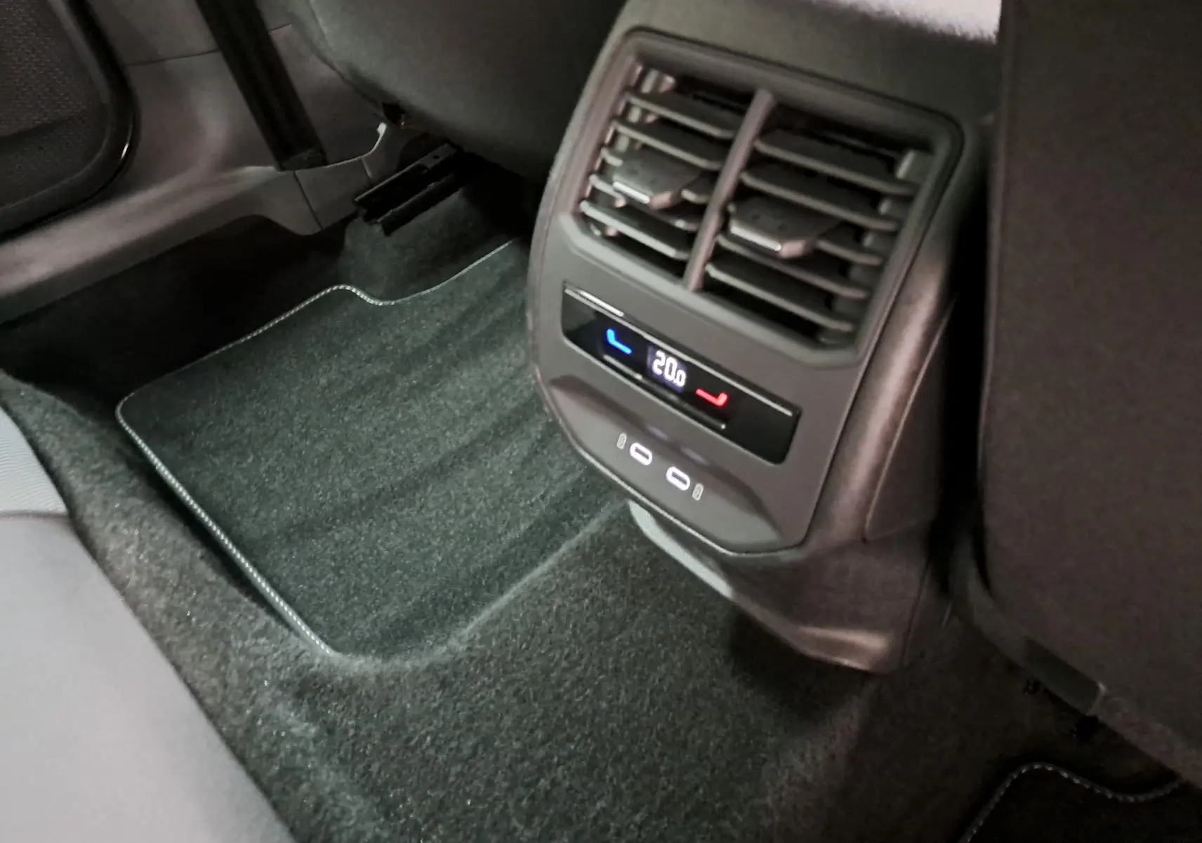 Vue rapprochée de la console arrière avec ventilation et commandes de climatisation à 20°C dans un SEAT Leon gris magnétique.
