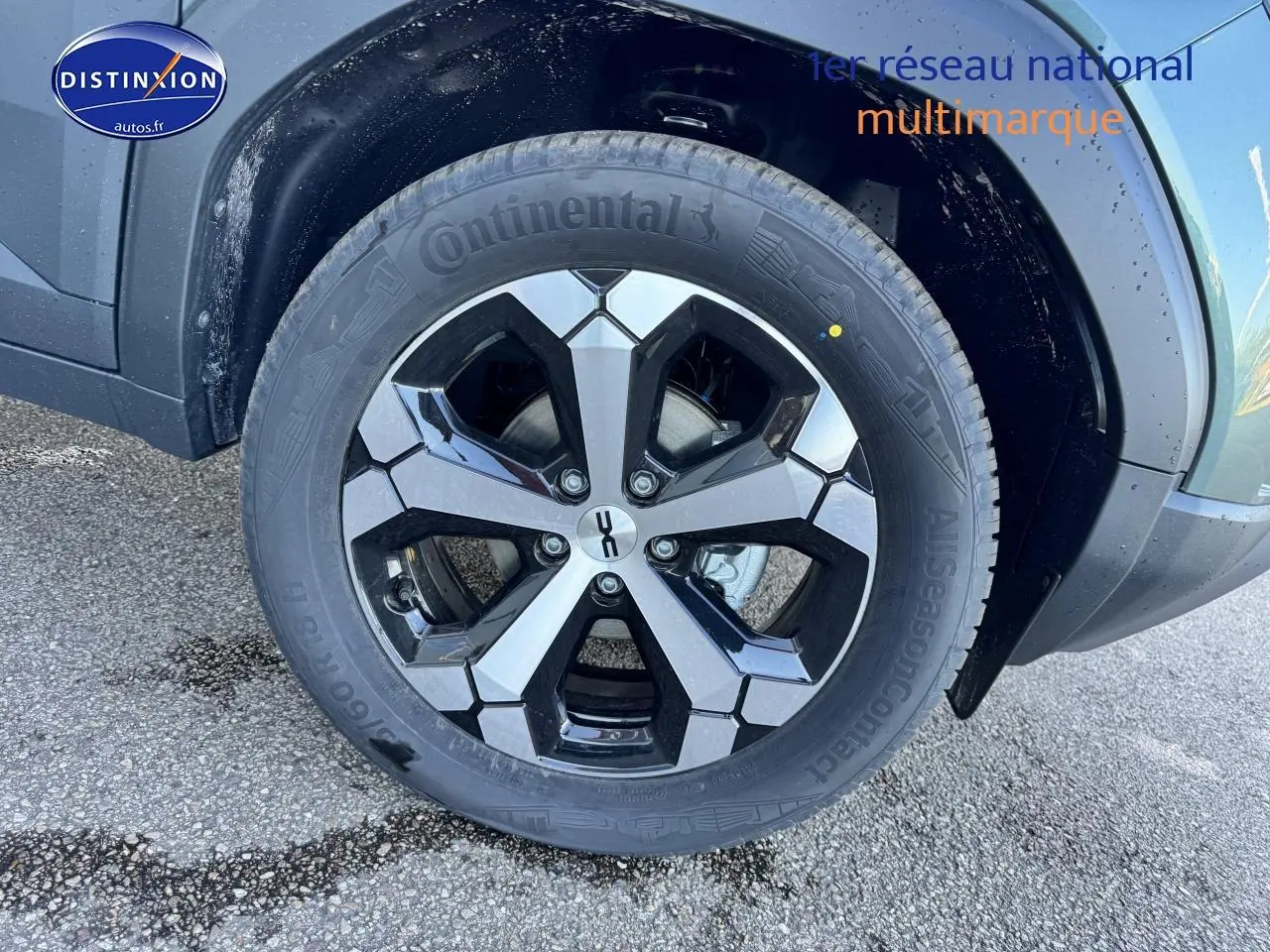 Gros plan sur la roue avant gauche du Dacia Duster vert cèdre, mettant en valeur la jante alu bicolore et le pneu Continental.