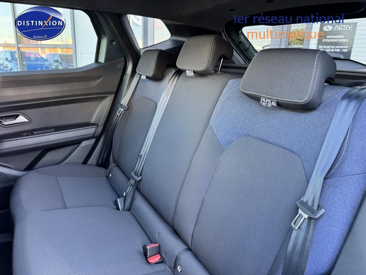 Vue intérieure de la banquette arrière du Dacia Duster 2025, tissu gris foncé avec appuie-têtes et ceintures visibles.