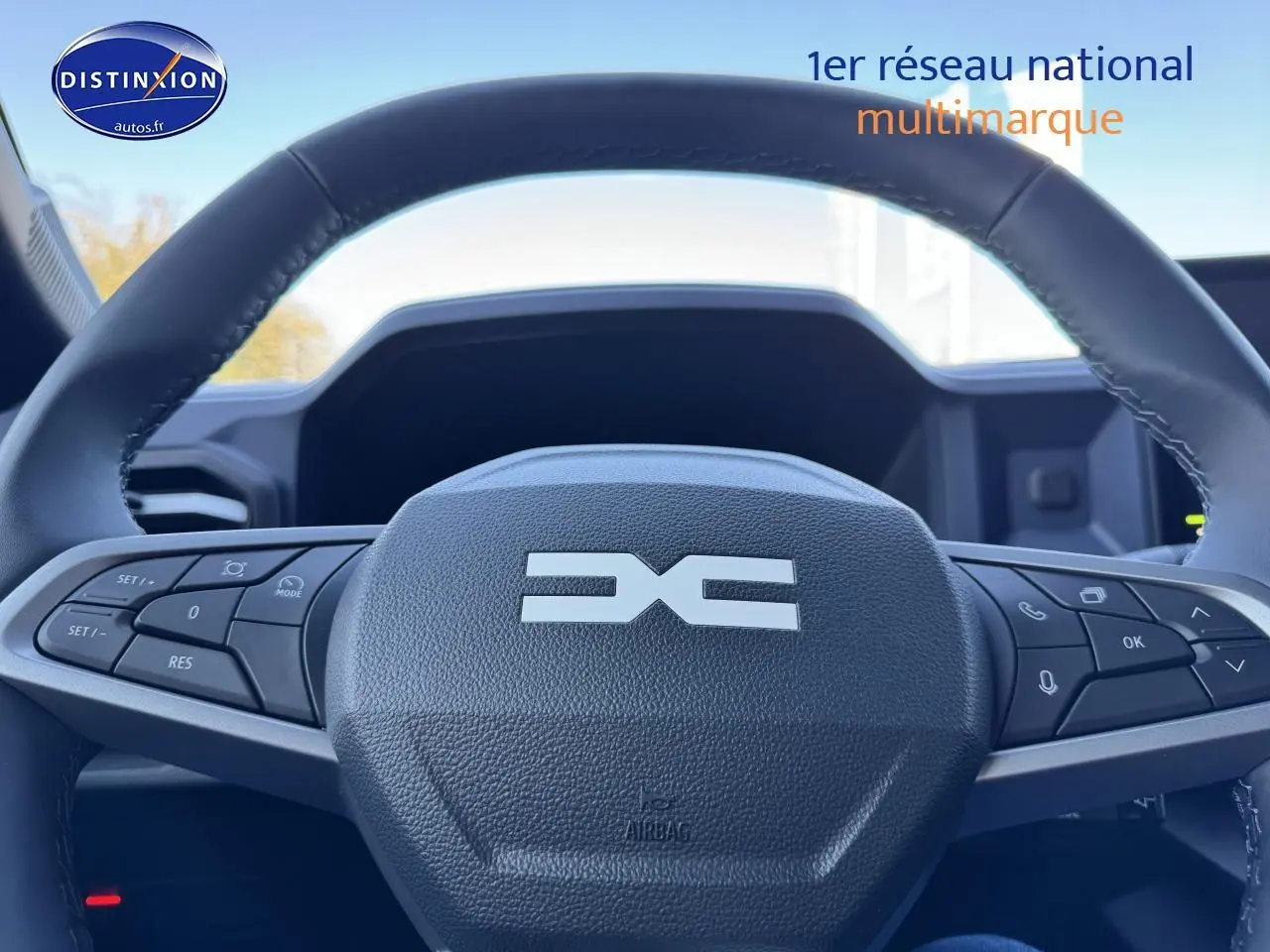 Gros plan sur le volant noir multifonction du Dacia Duster 2025, avec commandes intégrées visibles de face.