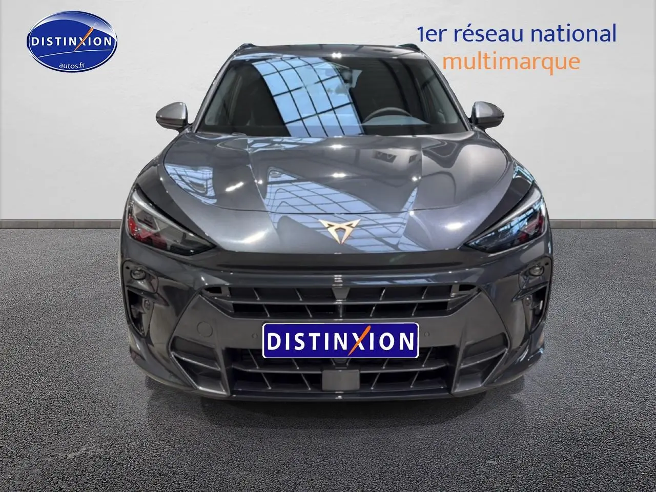 Vue frontale d'une CUPRA Terramar gris métallisé avec calandre large et logo CUPRA doré visible sur le capot.