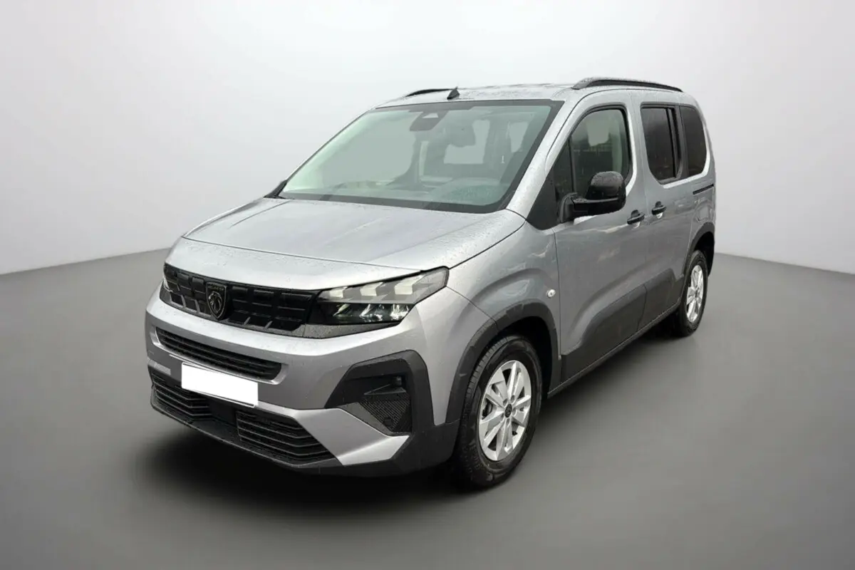Vue 3/4 avant droit d'un Peugeot Rifter BlueHDi 130 Allure gris Artense avec barres de toit et vitres surteintées.